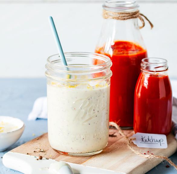 Vegane Mayonnaise in einem Glas mit Löffel.
