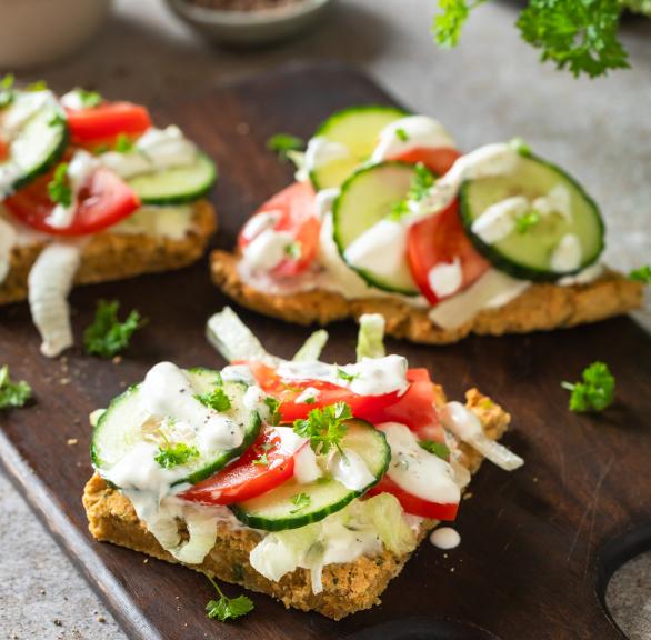 High-Protein Falafel Sandwiches mit Salat belegt auf einem Holzbrett