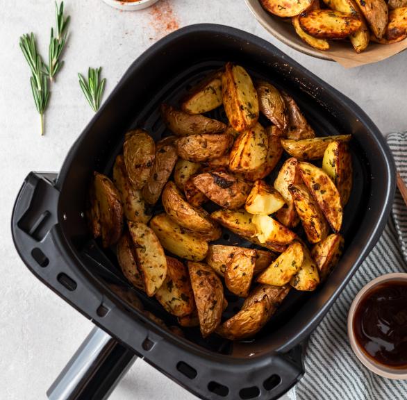 Wedges aus frischen Kartoffeln gewürzt und gebacken in einer Heißluftfritteusenschublade