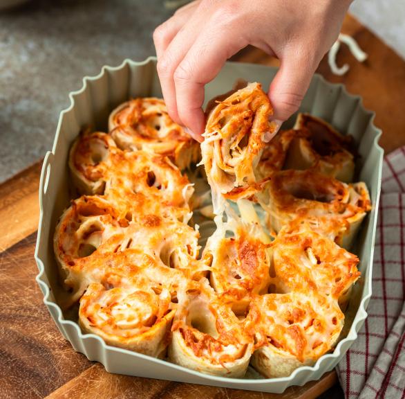 Piadina-Schnecken aus Wraps gefüllt mit Käse und Schinken in einer Auflaufform