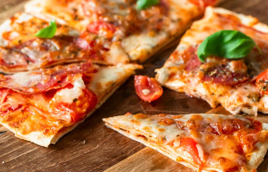 Wrap Pizza mit Salami auf einem Holzbrett