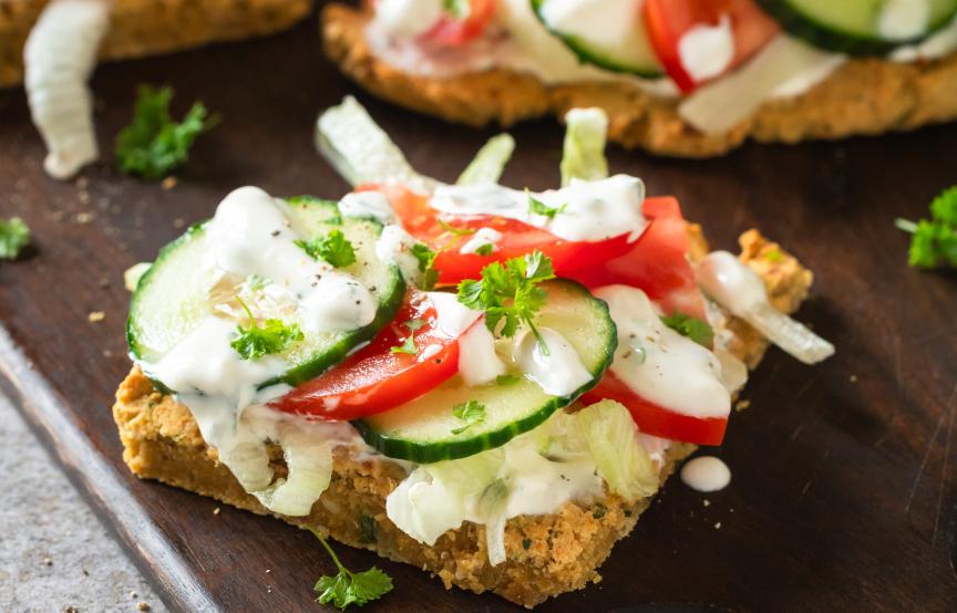 High-Protein Falafel Sandwiches mit Salat belegt auf einem Holzbrett