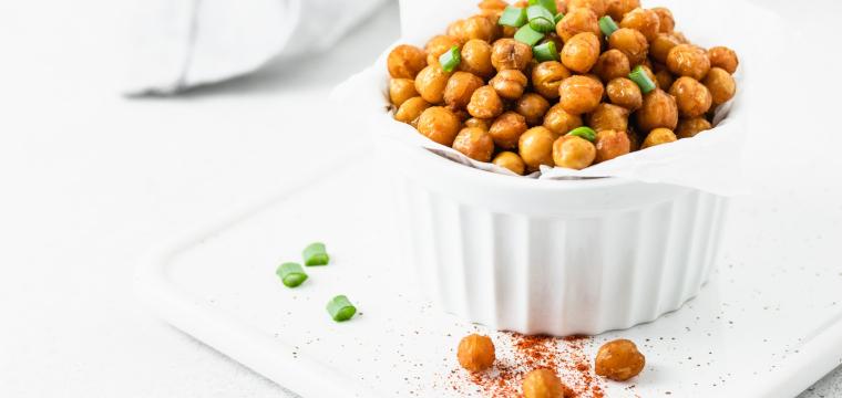 Heißluftfrittierte Kichererbsen in einer kleinen Schale, gewürzt und mit frischen Kräutern garniert