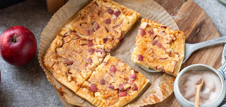 Apfelpfannkucen angeschnitten auf einem runden Backpapierzuschnitt vor einer Heißluftfritteuse