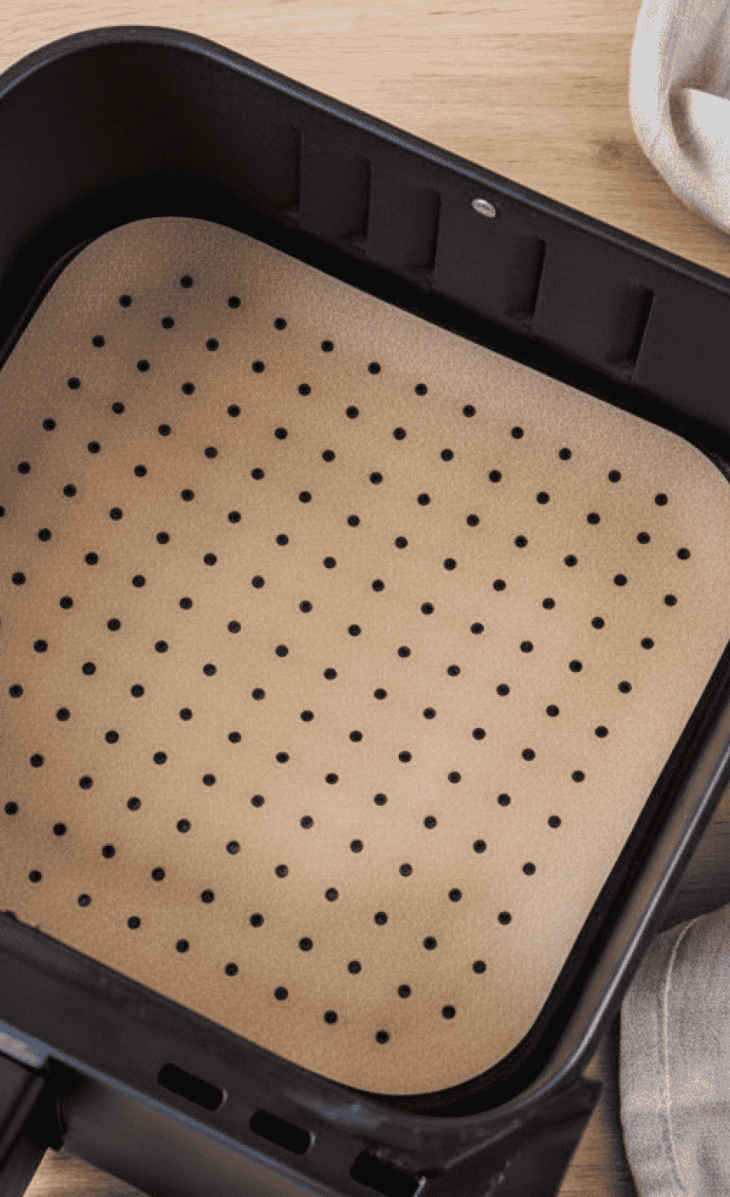 Gelochtes Backpapier im Garkorb eines Airfryers