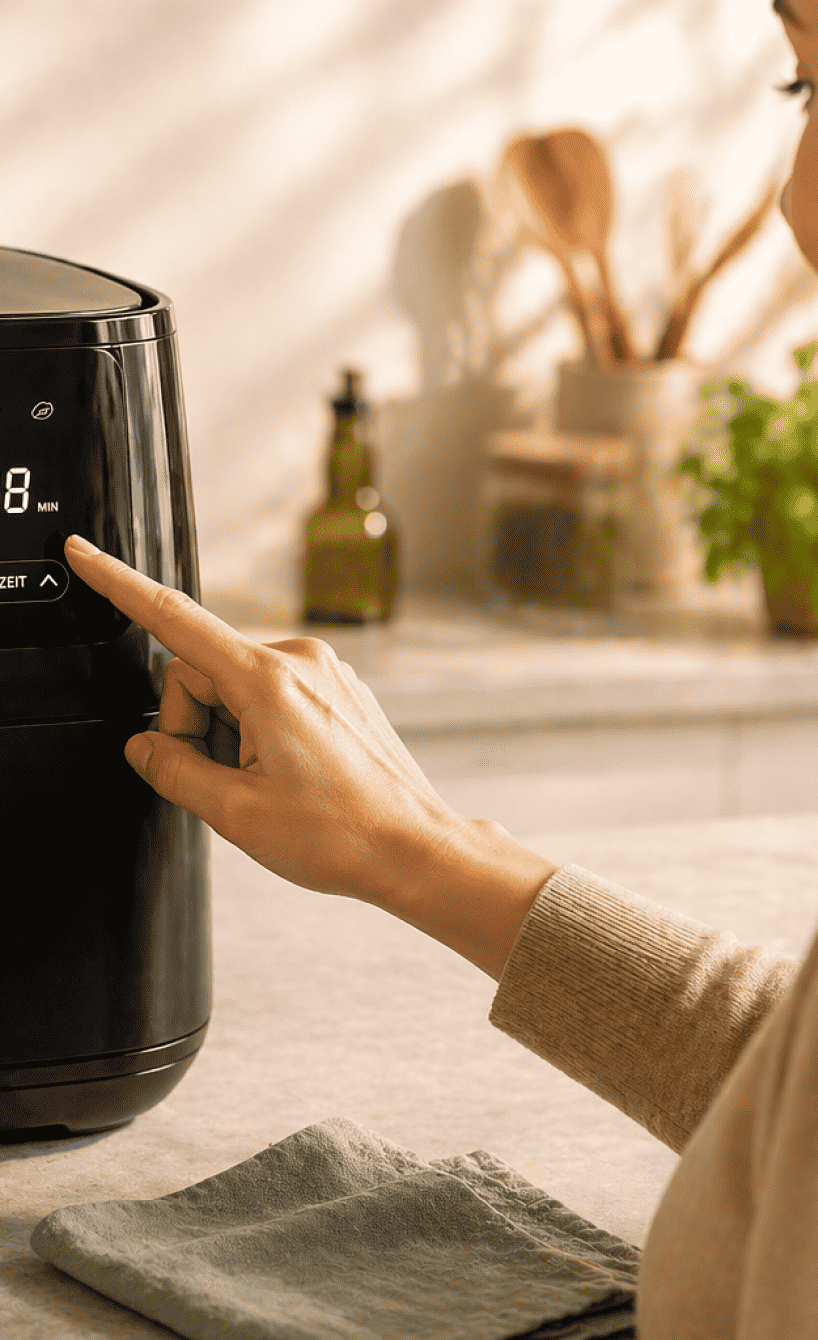 Eine Frau stellt die Temperatur beim Airfryer ein