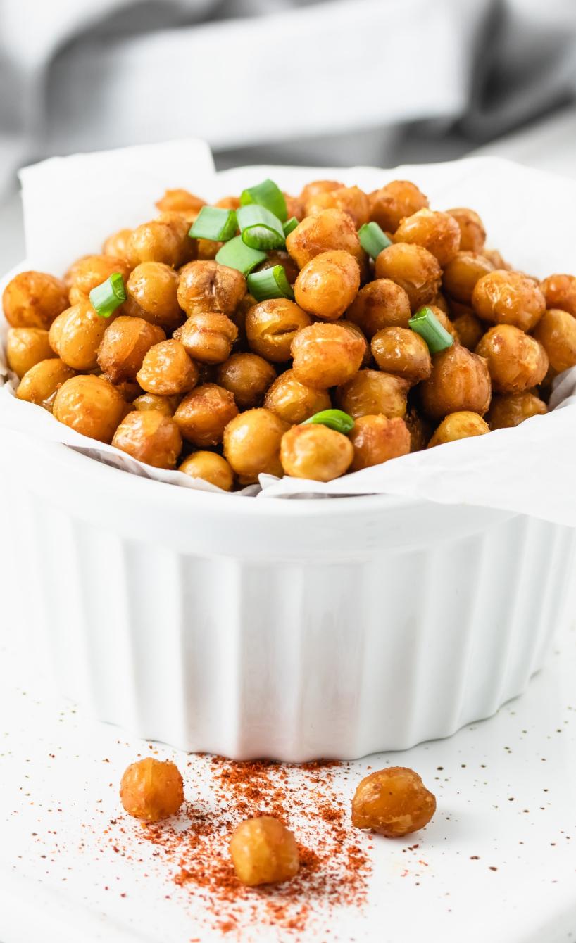 Heißluftfrittierte Kichererbsen in einer kleinen Schale, gewürzt und mit frischen Kräutern garniert