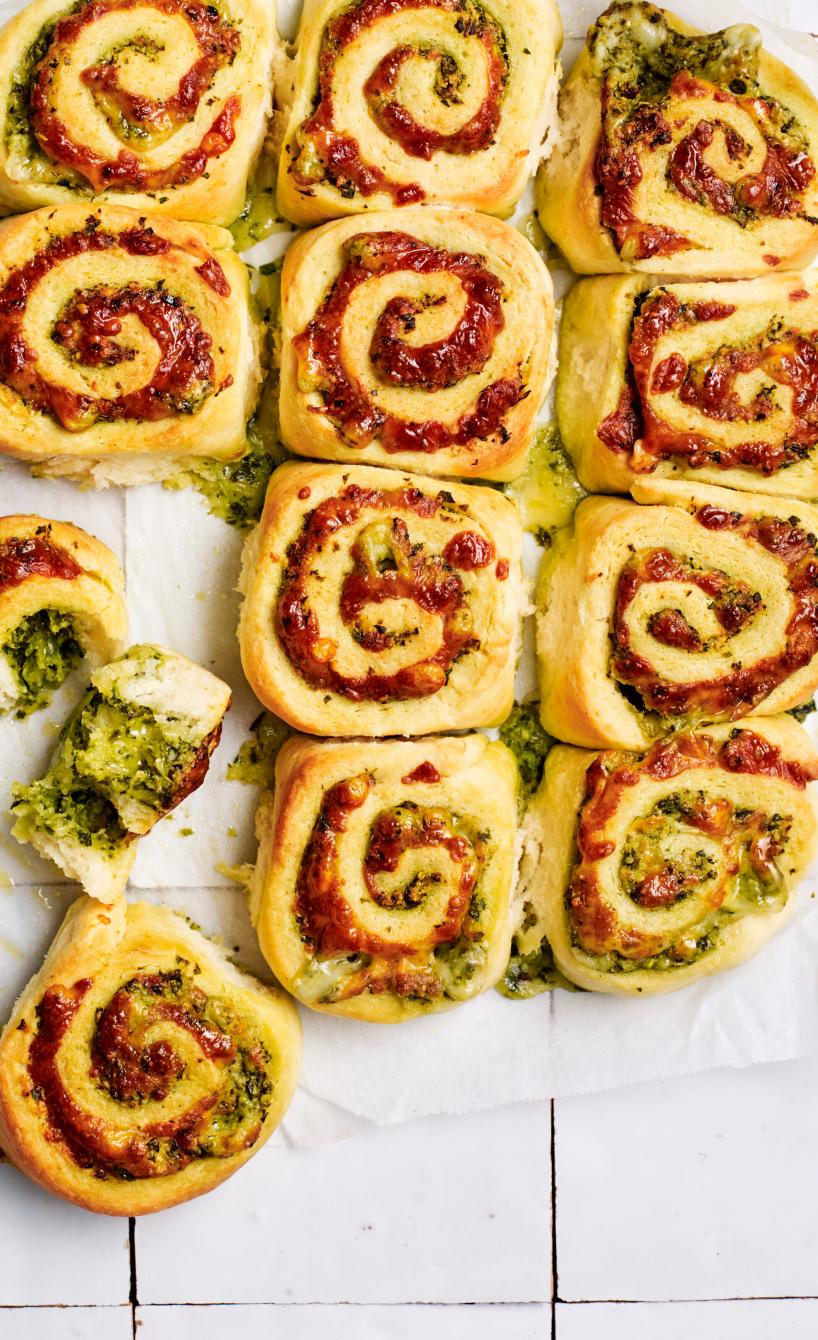 Selbstgebackene Pizzarollen mit Pesto und Tomatensoße auf einem Stück Backpapier