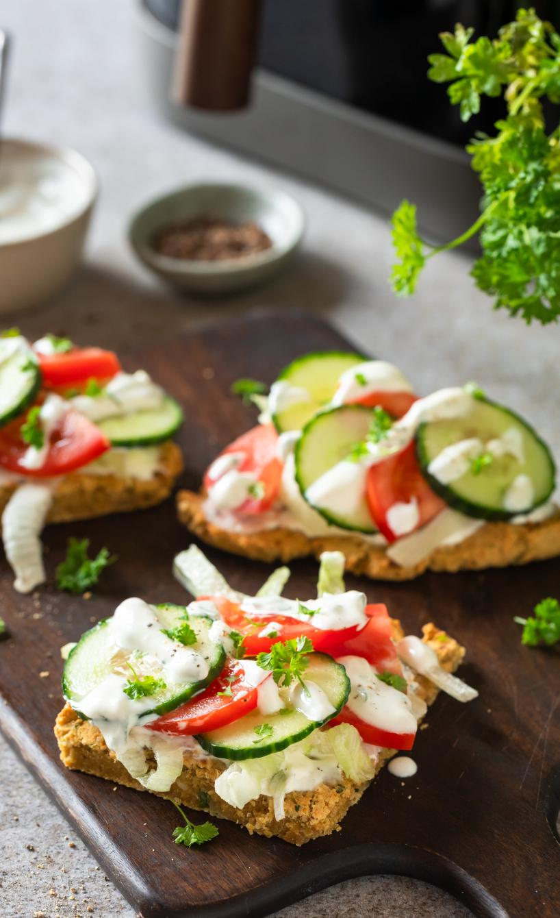High-Protein Falafel Sandwiches mit Salat belegt auf einem Holzbrett