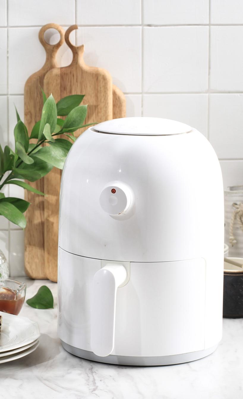 Eine weiße Mini-Heißluftfritteuse steht in auf einer Küchenarbeitsplatte